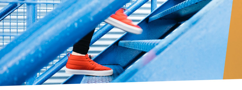 Rote Turnschuhe auf blauer Treppe