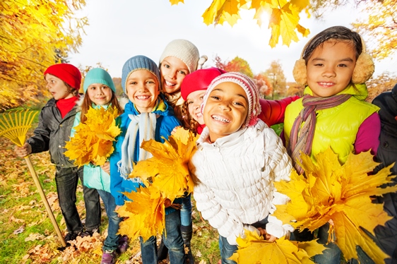 Kinder spielen im Herbstlaub