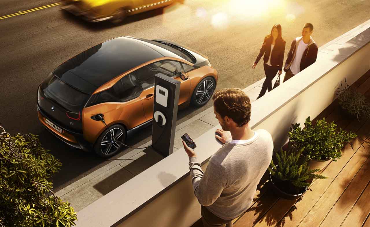 Foto: Nutzer macht auf seinem Smartphone Einstellungen f&uuml;r Ladevorgang seines E-Fahrzeugs.