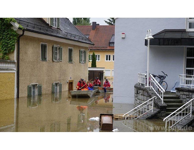 Feuerwehrleute und andere Helfer versuchen die Leute aus den Häusern zu holen