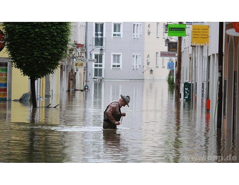 Ein älterer Mann kämpft sich durch die Wassermassen