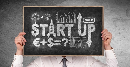 Mann h&auml;lt Tafel mit Text Startup