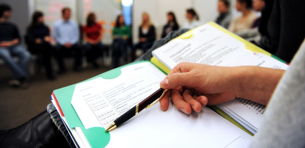 Ein Studierener zeigt auf einen Studientext