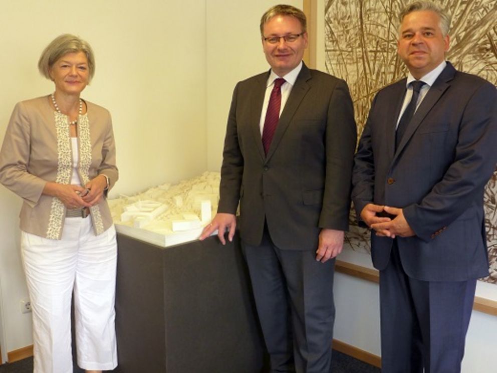 Foto mit Präsidentin Prof. Dr. Carola Jungwirth, Staatssekretär Josef Zellmeier und Kanzler Dr. Achim Dilling vor einem Modell des Spitzberg-Geländes. 