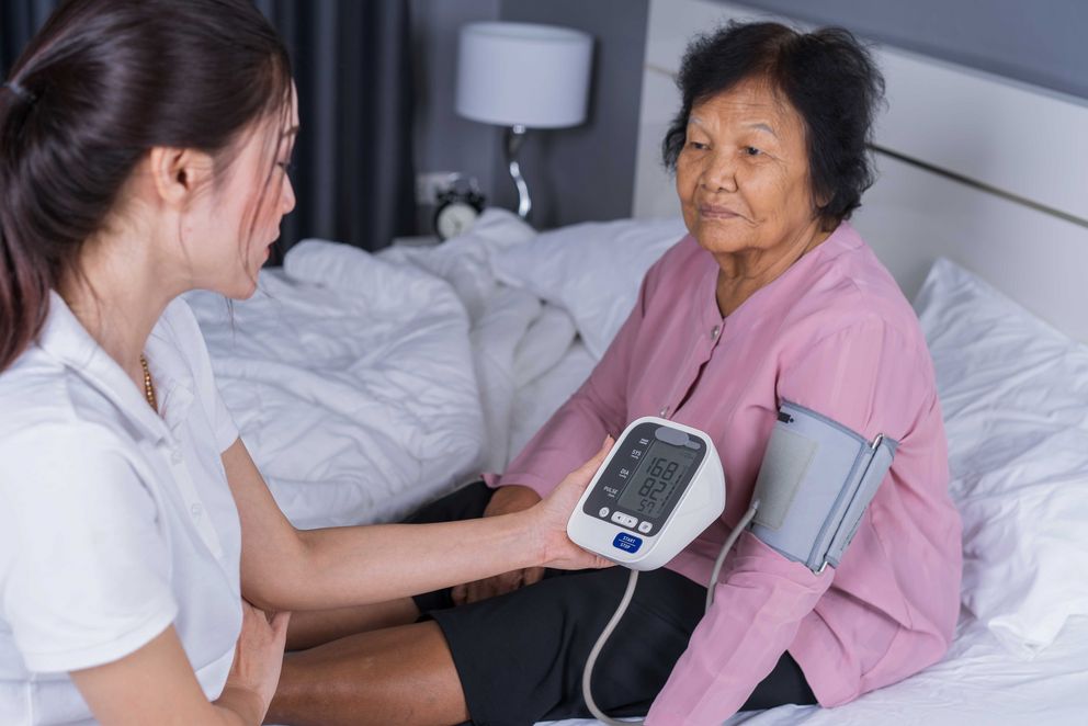 Symboldbild: Frau misst Blutdruck einer älteren Patientin