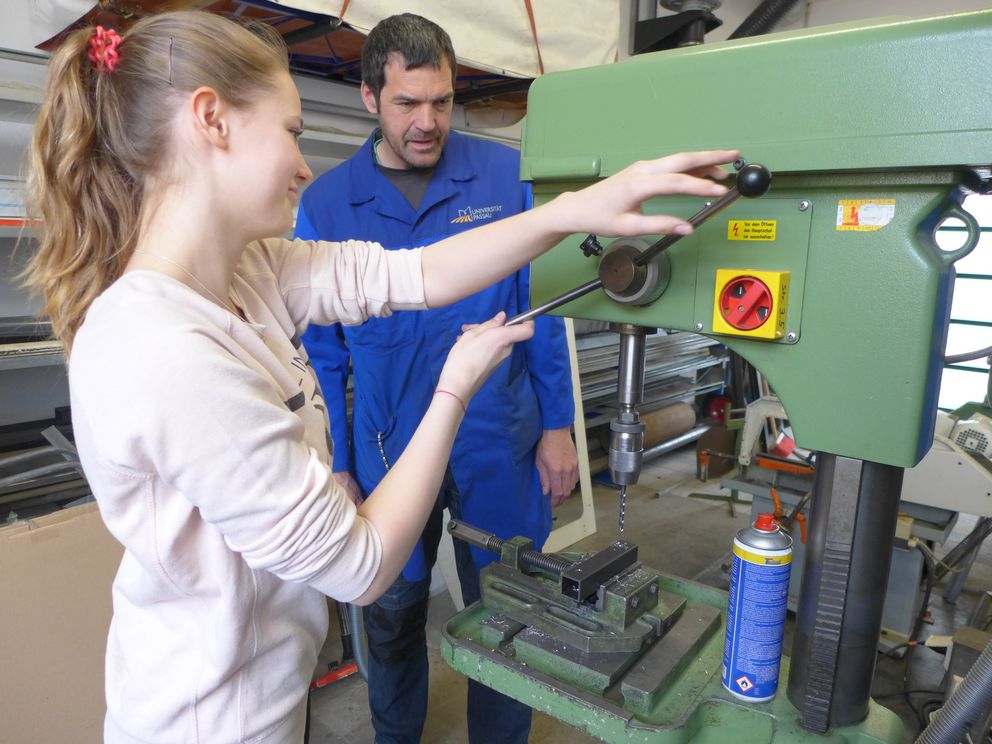 Eine Schülerin arbeitet in einer Werkstatt mit einer Bohrmaschine