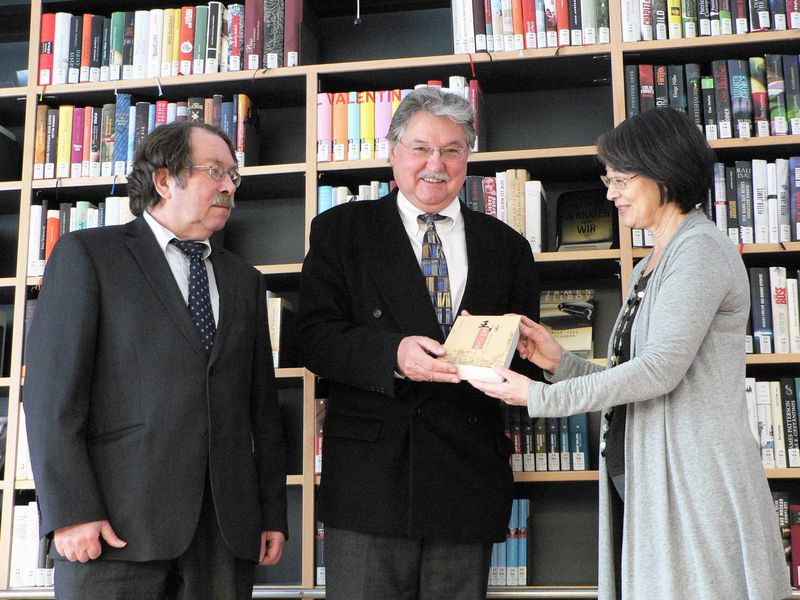 Prof. Ulrich Manthe, Leiter des Sprachenzentrums, Dr. Michael Weithmann, Universitätsbibliothek und Nelly Ma freuen sich über den Neuzugang in der Universitätsbibliothek Passau.
