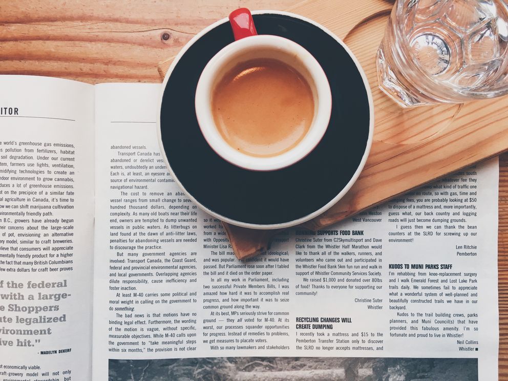Zeitung mit Kaffee und Wasserglas