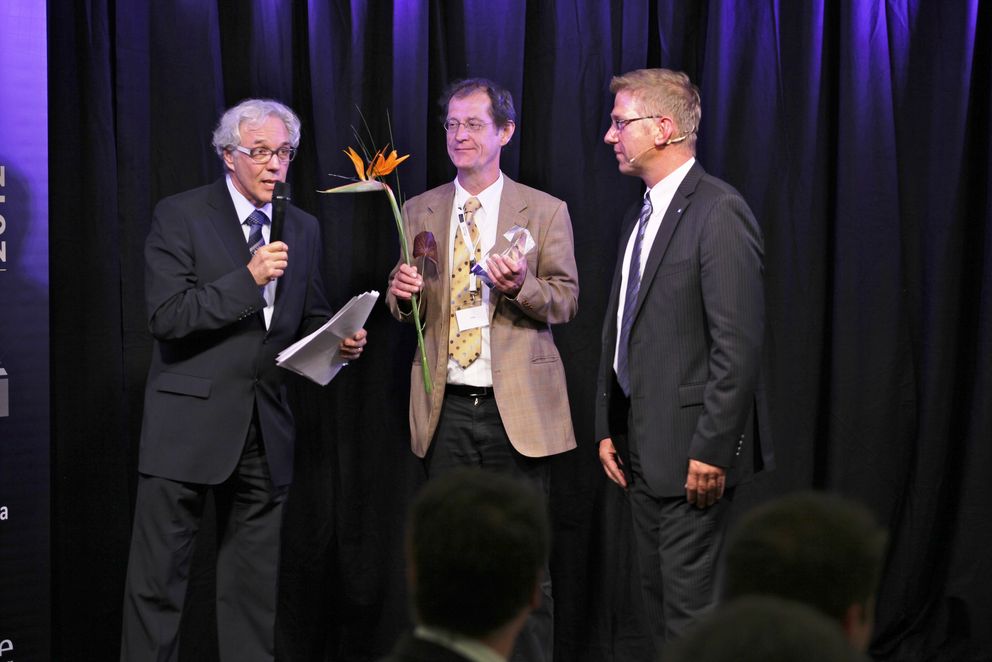 Prof. Dr.-Ing. Hermann de Meer (Mitte) bei der Preisverleihung in Sinsheim mit Moderator Gerd Harohn (l.) und Bernd Fleischer, Leiter Business Development, Zentralvertrieb des Sponsors Hochtief Solutions AG