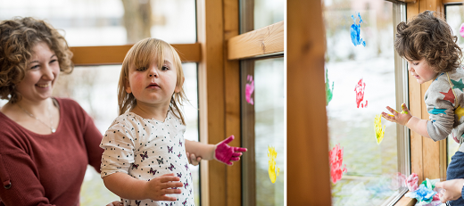 Rainier und Sophia von der Uni-Kinderkrippe "Krümelkiste" bringen mit Unterstützung von Erzieherin Sonja mit Fingerfarbe bunte Hände auf die Fensterscheiben in der Kinderecke